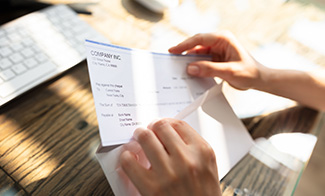 placing payroll check in envelope