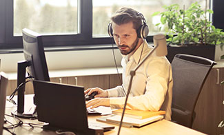 man working at home with laptop and headphones