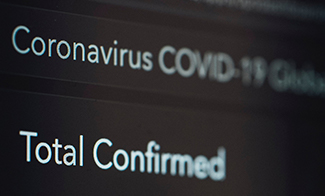 monitor displaying coronavirus total confirmed