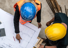 aerial view two construction workers reviewing plans