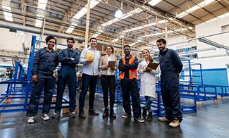 group-of-employees-on factory floor-looking-into-camera