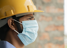 Close-up-side-view-of-man-in-hard-hat-and-Covid-face-mask
