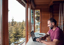 man-working-on-laptop from-cabin-in-the-woods