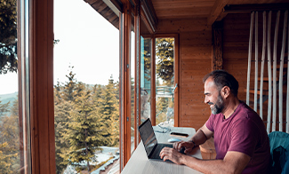 man-working-on-laptop from-cabin-in-the-woods