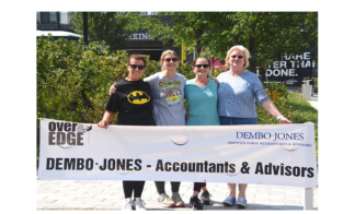 dembo-jones-employees-holding-special-olympics-banner