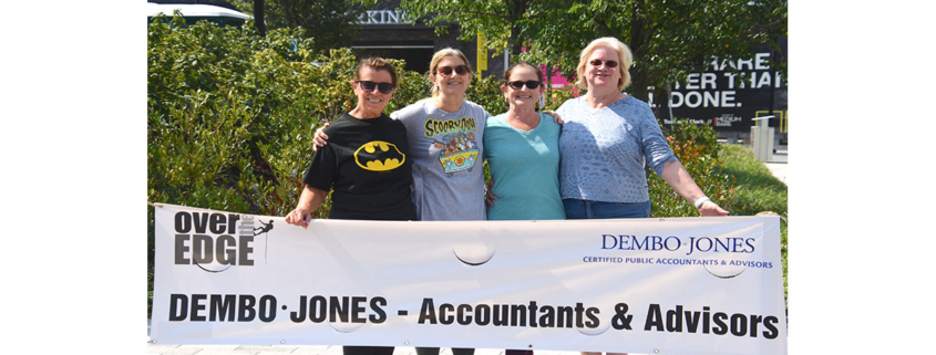 dembo-jones-employees-holding-special-olympics-banner