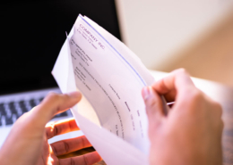 hands-opening-envelope-with-pay-check-inside