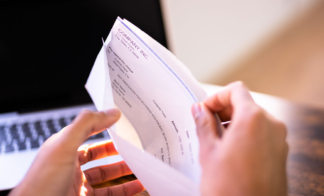 hands-opening-envelope-with-pay-check-inside